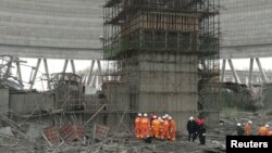 Rescue workers search the site where a power plant's cooling tower under construction collapsed, in Fengcheng, Jiangxi province, China, Nov. 24, 2016.