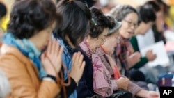 한국 대학 입학 시험인 '수능'을 하루 앞둔 11일, 서울 조계사에서 학부모들이 자녀들을 위해 기도하고 있다.