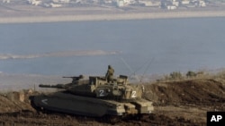 Tentara Israel berdiri di atas tank mengawasi perbatasan di Dataran Tinggi Golan (foto: dok). 