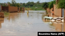 Un enfant patauge dans l'eau dans une rue inondée de Niamey. (photo d'archives)