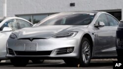 This July 8, 2018, file photo shows Tesla 2018 Model 3 sedans sitting on display outside a Tesla showroom in Littleton, Colo. (AP Photo/David Zalubowsi, File)