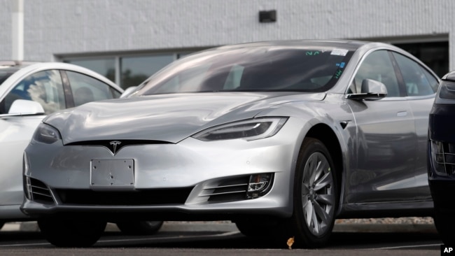 This July 8, 2018, file photo shows Tesla 2018 Model 3 sedans sitting on display outside a Tesla showroom in Littleton, Colo. (AP Photo/David Zalubowsi, File)