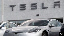 This July 8, 2018, file photo shows Tesla 2018 Model 3 sedans sitting on display outside a Tesla showroom in Littleton, Colo. (AP Photo/David Zalubowsi, File)