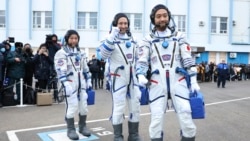 In this photo released by the Roscosmos Space Agency, Roscosmos cosmonaut Alexander Misurkin, center, and spaceflight participants Yusaku Maezawa, left, and Yozo Hirano, right, of Japan, members of the main crew of the new Soyuz mission to the International Space Station (ISS) walk prior to the launch at the Russian leased Baikonur cosmodrome, Kazakhstan, Wednesday, Dec. 8, 2021. (Pavel Kassin/Roscosmos Space Agency via AP)