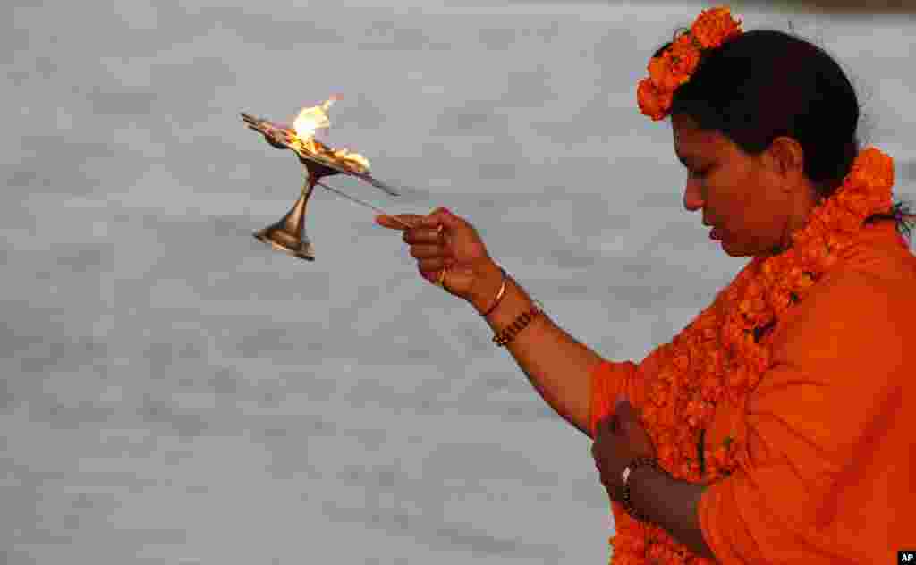 Mahant Trikaal Bhawanta, leader of the first group of women sadhvi, or Hindu holy women, performs evening rituals on the banks of River Yamuna in Allahabad, India. 