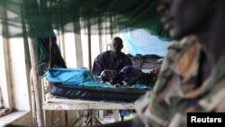 A child sick with malaria and from malnutrition lies on a bed in a hospital in Bor, South Sudan, March 15, 2014.