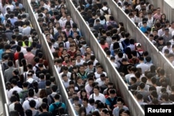 Passengers line up and wait for a security check during morning rush hour at Tiantongyuan North Station in Beijing.