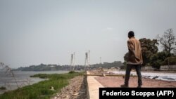 Un homme marche sur les rives du fleuve Congo où une nouvelle route côtière est construite le 22 juillet 2015 à Brazzaville.