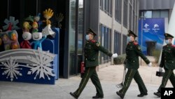 中国武警士兵在北京冬奥会吉祥物前走过。（2022年1月21日）