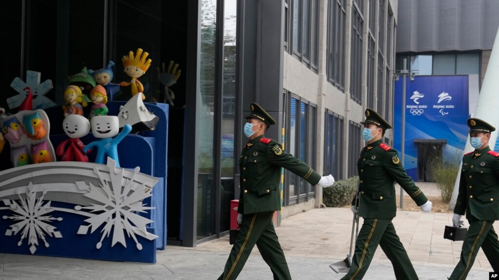 中国武警士兵在北京冬奥会吉祥物前走过。（2022年1月21日）(photo:VOA)