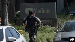 Officers run toward a YouTube office in San Bruno, Calif., Tuesday, April 3, 2018. Police and federal officials have responded to reports of a shooting Tuesday at YouTube headquarters in Northern California. 