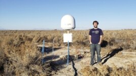 This undated photo provided by Caltech shows radio astronomer Christopher Bochenek with a STARE2 station he developed near the town of Delta, Utah. (Caltech via AP)