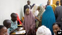 Detained Somali women are fingerprinted and screened at the Kasarani sports stadium, which has been converted into a detention facility to hold those arrested during recent security crackdowns, near Nairobi, April 9, 2014.