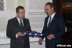 Entoni Godfri, novi ambasador Sjedinjenih Država u Srbiji i ministar inostranih poslova Srbije Ivica Dačić polažu zastavu SAD koja se zajedno sa zastavom Srbije vijorila na Beloj kući u Vašingtonu pre 100 godina, u Muzeju srpske diplomatije u Beogradu, 28. oktobra 2019. (Foto: Ministarstvo spoljnih poslova Srbije)