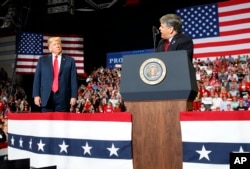 FILE - President Donald Trump listens Fox News' Sean Hannity during a rally in Cape Girardeau, Mo., Nov. 5, 2018. In a June 2024 interview with Hannity, Trump said he "would have every right" to seek revenge against his political opponents.