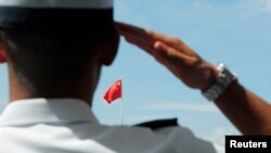 一名驻香港海军基地的中国海军士兵向中国国旗敬礼。（2019年6月30日）