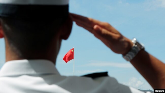 一名驻香港海军基地的中国海军士兵向中国国旗敬礼。(2019年6月30日)