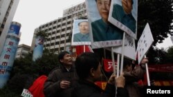 Người biểu tình cầm chân dung lãnh tụ Mao Trạch Đông bên ngoài văn phòng của tờ Nam Phương Tuần báo ở Quảng Châu, ngày 9/1/2013.