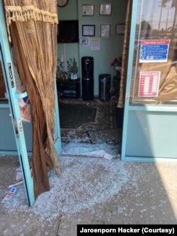 This file photo provided by Jaroenporn Hacker shows the glass door that was smashed and broken into the Thai Spa &Acupuncture, a Thai massage shop in Chatsworth, CA, early August 9, 2021.