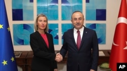 Turkish Foreign Minister Mevlut Cavusoglu, right, shakes hands with the European Union's foreign policy chief Federica Mogherini prior to their meeting, in Ankara, Turkey, Thursday, Nov. 22, 2018. 