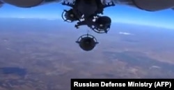 An image grab made from a video released Oct. 5, 2015, by the Russian Defense Ministry reportedly shows a Russian aircraft dropping bombs during an airstrike against Islamic State group's positions at an undisclosed location in Syria.