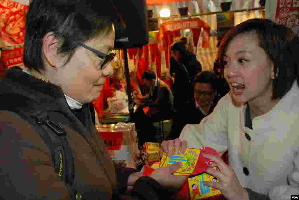 香港市民梁小姐對政黨的年宵攤位有興趣，她接受和平佔中的利是封