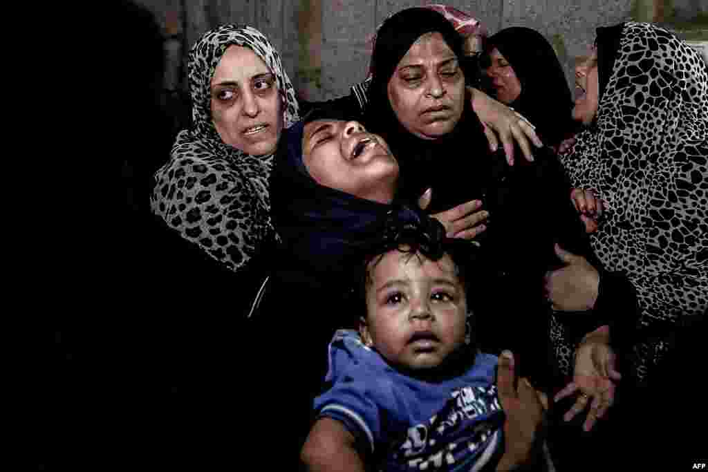 Palestinian relatives of Ahmad Murjan, the young Hamas fighter killed by Israeli fire, mourn his death during the funeral in Jabalia, in the northern Gaza Strip.