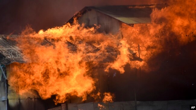 A building burns in Chinatown, Honiara, Solomon Islands, Friday, Nov. 26, 2021. (AP Photo/Piringi Charley)