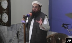 FILE - Hafiz Saeed, head of Jamaat-ud-Dawa, gives a Friday sermon at a mosque in Lahore, Pakistan, Nov. 24, 2017.