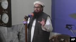 FILE - Hafiz Saeed, head of the Pakistani religious party Jamaat-ud-Dawa delivers a sermon at a mosque in Lahore, Pakistan, Nov. 24, 2017. Saeed has announced his group will field candidates in national and provincial elections in 2018.