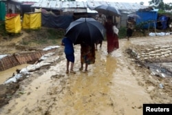People walk after a storm at Balukhali refugee camp in Cox's Bazar, Bangladesh June 10, 2018, in this image obtained from social media. (K. Marton/Save the Children/via Reuters)