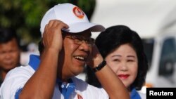 Cambodia's Prime Minister Hun Sen and his wife Bun Rany (R) arrive at an election campaign area in Phnom Penh, June 27, 2013. 