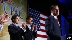 Republican presidential candidate Mitt Romney is applauded by sons Josh, center, and Tagg, left, as he speaks at a Colorado Conservative Political Action Committee meeting in Denver, Oct. 4, 2012.
