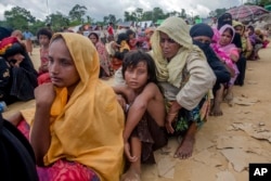 Rohingya Muslims, who recently crossed over from Myanmar into Bangladesh, wait for their turn to receive food aid near Balukhali refugee camp, Bangladesh, Friday, Sept. 15, 2017. Thousands of Rohingya are continuing to stream across the border.