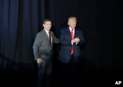 FILE - Retired Gen. Michael Flynn, left and President Donald Trump at rally.