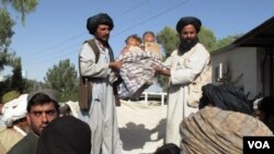 Warga sipil di provinsi Helmand menunjukkan dua anak kecil yang menjadi korban serangan udara NATO (29/5).