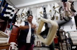 Carlos Antonio Nino spools wool to make ruanas, a traditional Colombian garment, in Nobsa, Colombia, Aug., 25, 2017. A ruana is a poncho-style outer garment typical of the Andes region of Colombia.