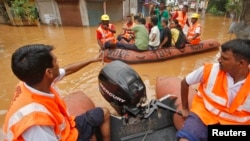 India's National Disaster Response Force personnel use rafts to rescue flood-affected residents after heavy rains at Guwahati in the northeastern Indian state of Assam, June 27, 2014. 