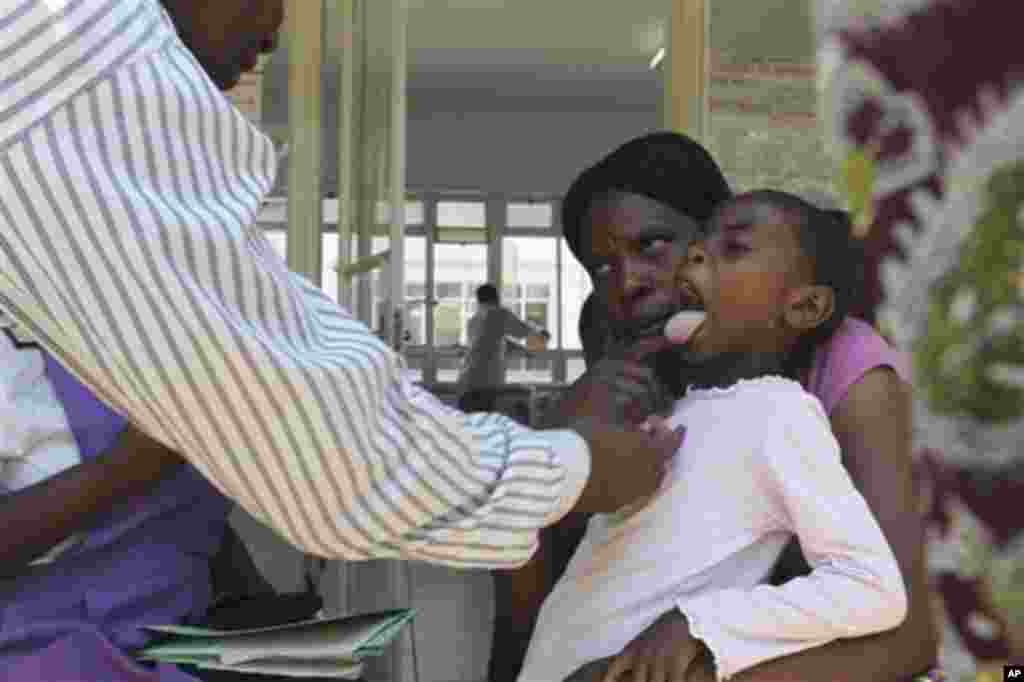 A doctor examins a child suffering from typhoid at a local infectious disease hospital in Harare, Tuesday, Nov.15, 2011. Health authorities say 207 cases of typhoid, spread by contaminated water and food, are being treated in Zimbabwe's capital after a pr
