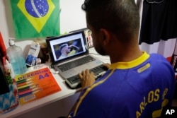 Carlos Junior, who is both deaf and blind, uses a braille display to read soccer news as he prepares to leave his home to follow the World Cup match between Brazil and Mexico in Sao Paulo, Brazil, July 2, 2018.