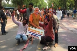 Bharatiya Janata Party workers celebrate, holding up a cardboard cut-out of Prime Minister Modi, in New Delhi, India, March 11, 2017. (A. Pasricha/VOA).