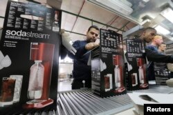 FILE - Employees pack boxes of SodaStream appliances at its factory in the West Bank Jewish settlement of Maale Adumim Jan. 28, 2014.