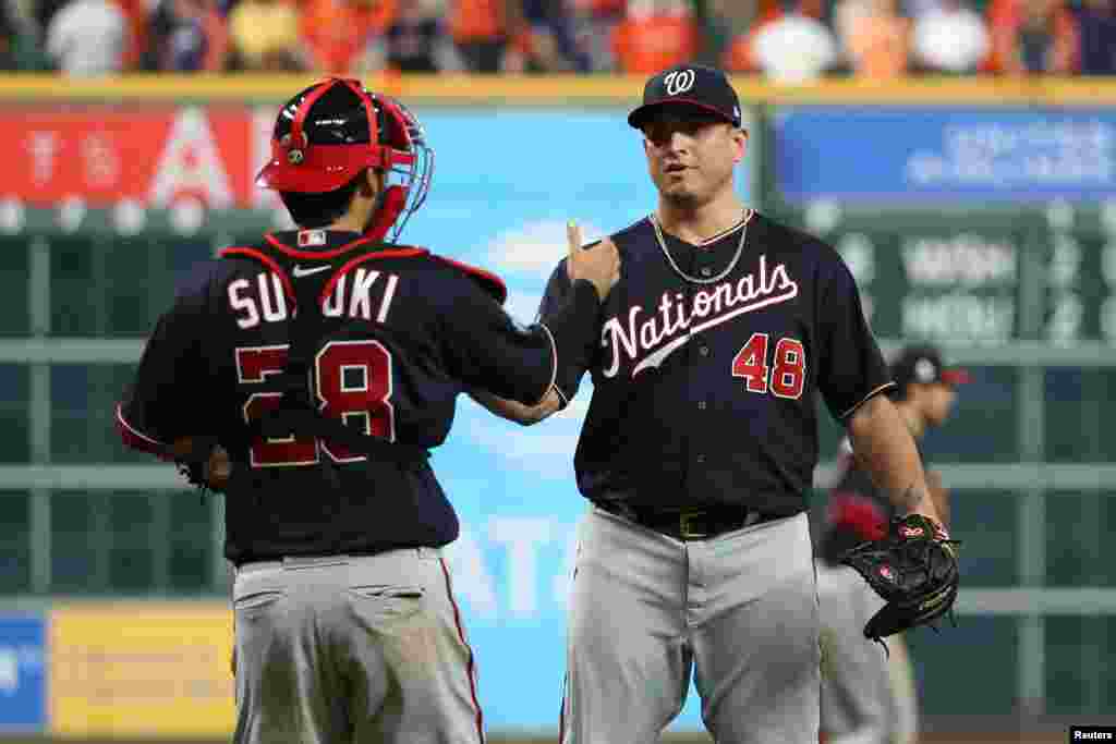 El catcher de los Nacionales de W., Kurt Suzuki (28) saluda al lanzador Javi Guerra al concluir el 2do partido ganado alos Astros el 23 de octubre de 2019. Reuters.