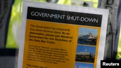 Security officer Jarvis Landlum holds a sign informing people on the government shutdown of Alcatraz Island, a tourist attraction operated by the National Park Service, in San Francisco, California Oct. 1, 2013.