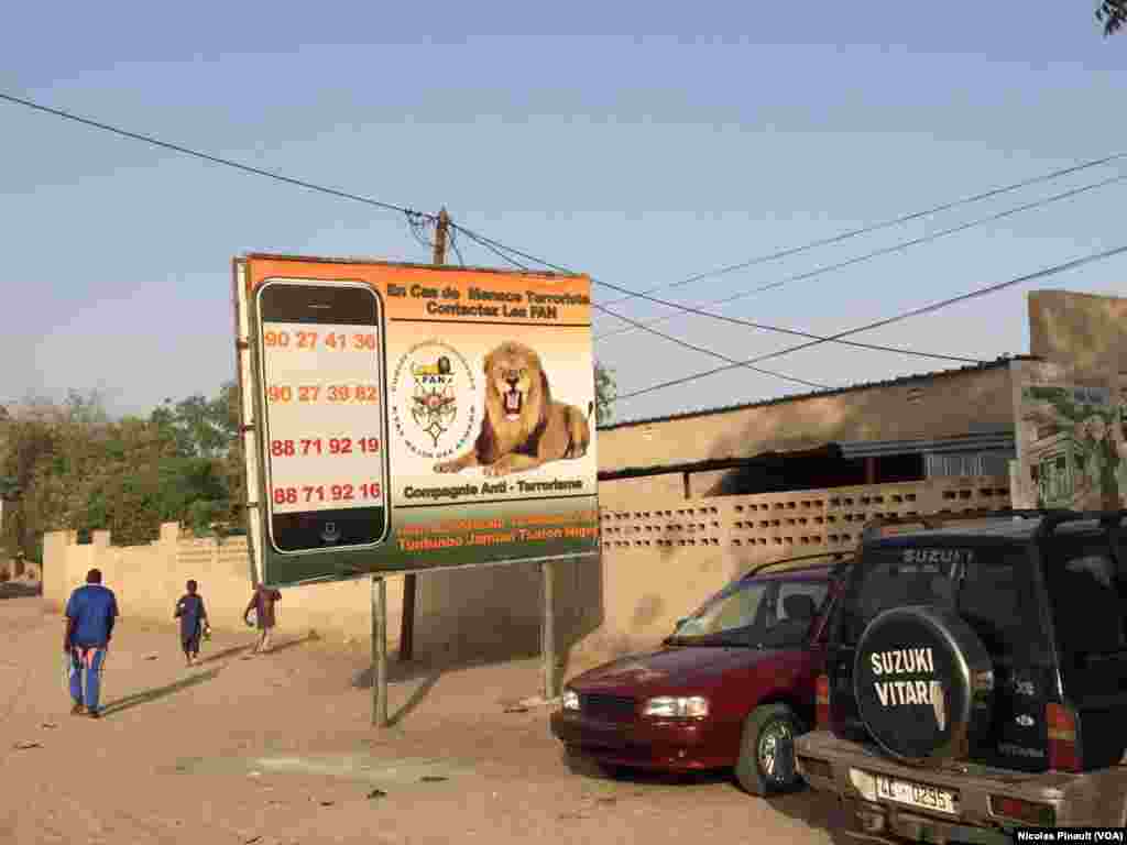 Panneau publicitaire demandant à la population de contacter les forces armées du Niger en cas de menace terroriste. Diffa, le 1er mars 2016. (VOA/Nicolas Pinault)