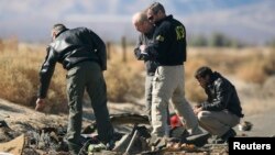 Investigators from the National Transportation Safety Board (NTSB) look at wreckage from the crash of Virgin Galactic's SpaceShipTwo near Cantil, California, Nov. 2, 2014. 