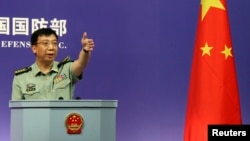 FILE - Spokesman of China's Defense Ministry Geng Yansheng gestures to a journalist after his speech during a news conference in Beijing.
