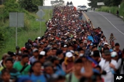 Migrants, part of a caravan traveling from Central America toward the United States, walk on a road that links Ciudad Hidalgo with Tapachula, Mexico, Nov. 2, 2018.