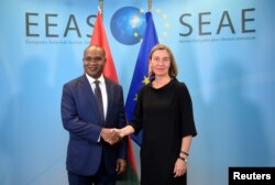 FILE - EU foreign policy chief Federica Mogherini welcomes Burkina Faso Foreign Minister Alpha Barry, left, before a G-5 Sahel Ministerial meeting at EU headquarters in Brussels, Belgium, June 18, 2018.