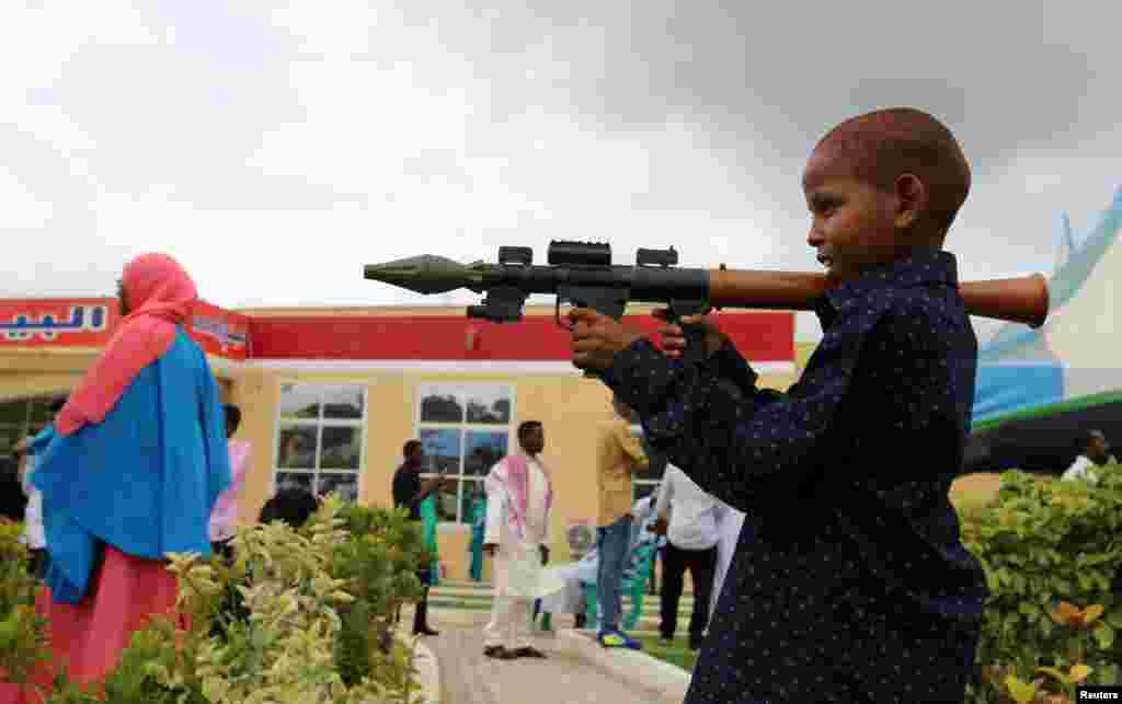 A boy plays with a toy model of a rocket-propelled grenade (RPG) after attending Eid al-Fitr prayers to mark the end of the fasting month of Ramadan in the capital Mogadishu, July 6, 2016.
